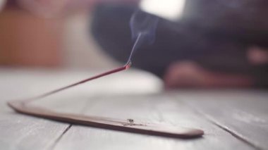 Tütsü tütsüsü yere yakın çekim ve arka planda yoga.