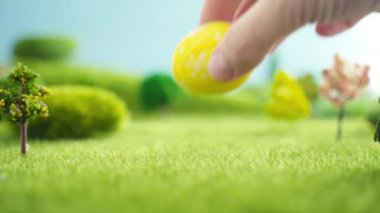 Hayal ürünü bir makrokozmozla çimin üzerine paskalya yumurtası seriyorum.
