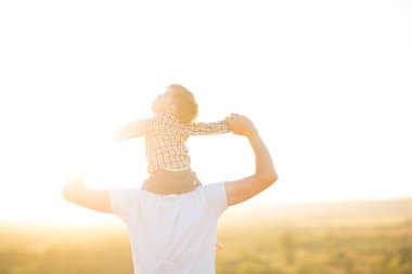 Sıcak ve güneşli bir günde parkta mutlu bir baba ve oğul. Aile ve aşk kavramı