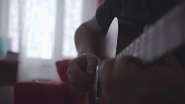 Gitar çalan bir adamın elinin yakın çekimi..
