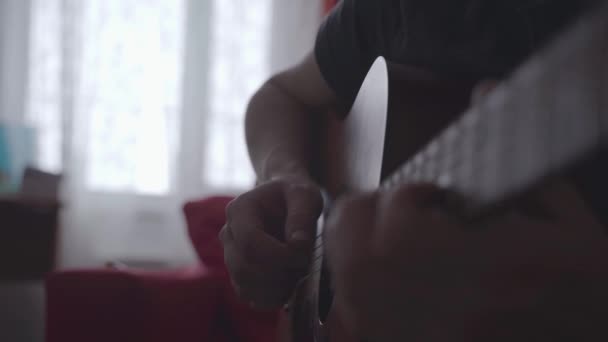 Närbild av en mans händer spelar gitarr. — Stockvideo