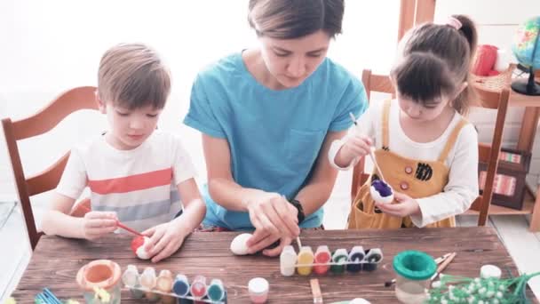 Veselé Velikonoce. Rodina s dětmi malování vajíček na Velikonoce — Stock video