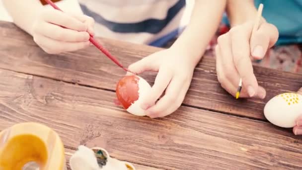 Frohe Ostern. Familie mit Kindern bemalt Eier für Ostern — Stockvideo