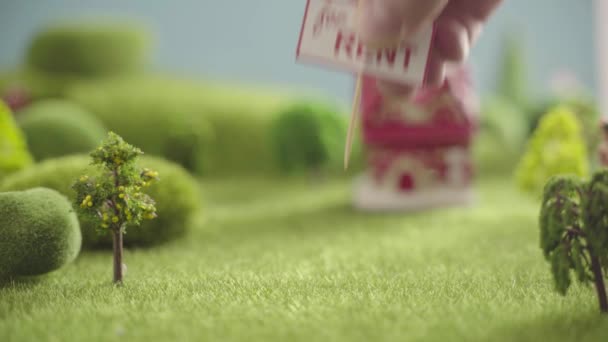 Haus Zu vermieten Zeichen. Spielzeughaus auf einem Feld mit Bäumen — Stockvideo