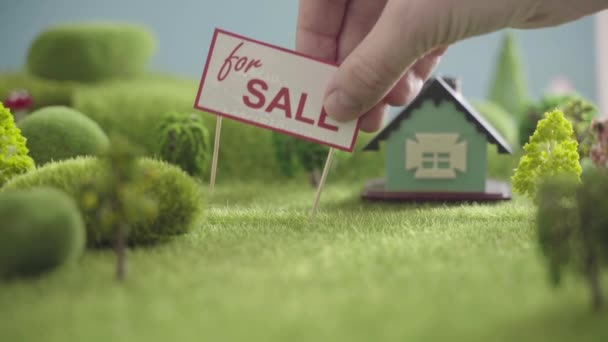 Rumah untuk dijual. Toy house in a field with trees — Stok Video