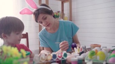 Mutlu Paskalyalar. Paskalya için yumurta boyayan bir anne ve oğul.