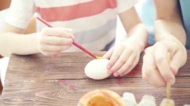 Mutlu Paskalyalar. Paskalya için yumurta boyayan çocuklu aile.