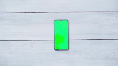 Masada krom anahtarı olan akıllı bir telefon. Yukarıdan görüntüle
