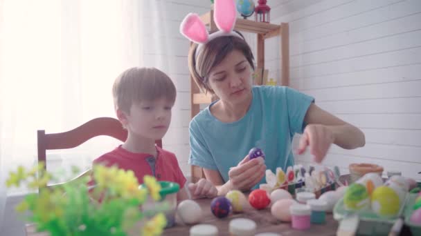 Happy easter. Family mother with son painting eggs for easter