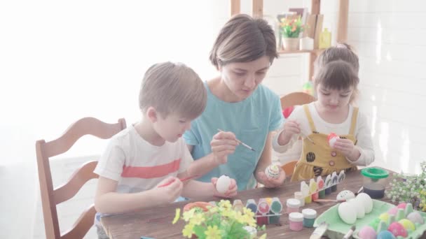 행복 한 어른. 아이들 이 아이를 위해 달걀에 그림을 그리는 가족 — 비디오