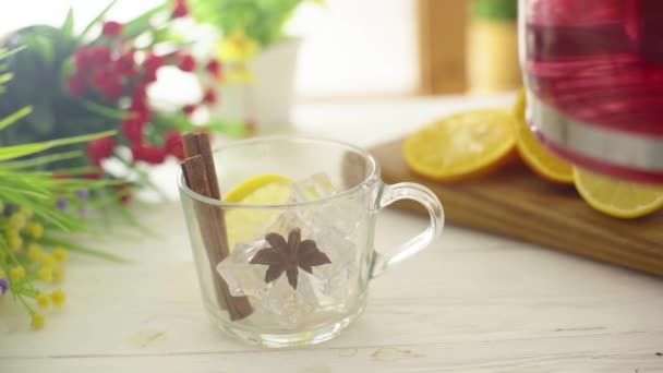 El té se vierte en una taza transparente de vidrio sobre una mesa de madera — Vídeos de Stock