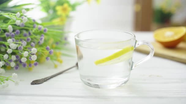 O chá é derramado em um copo transparente de vidro em uma mesa de madeira — Vídeo de Stock