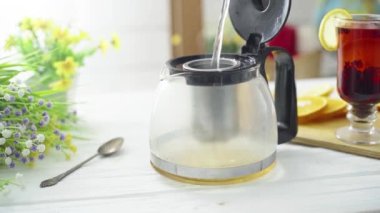 Çay, ahşap bir masada şeffaf bir kaba dökülür.