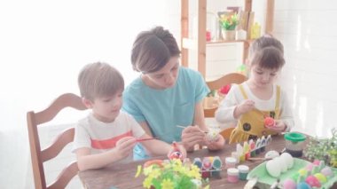 Mutlu Paskalyalar. Paskalya için yumurta boyayan çocuklu aile.