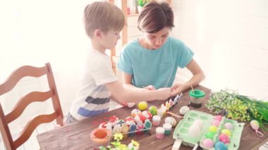 Mutlu Paskalyalar. Paskalya için yumurta boyayan çocuklu aile.