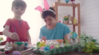 Mutlu Paskalyalar. Paskalya için yumurta boyayan bir anne ve oğul.