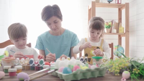 Gledelig østlig. Familie med barn som maler egg til østlig mat – stockvideo