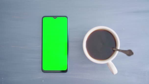 한 남자 가손으로 스마트폰을 사용하여 크롬 키를 가지고 커피를 숟가락 과 혼합 한다 — 비디오
