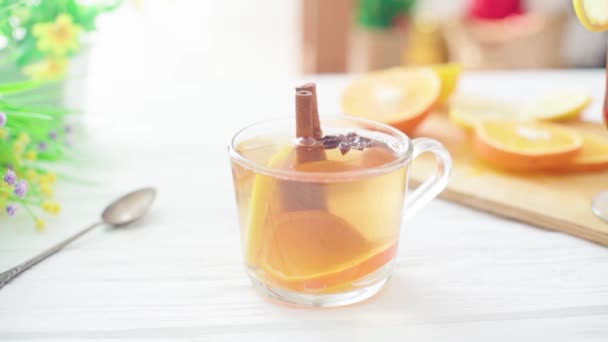 Čaj se nalévá do skleněného průhledného kelímku na dřevěném stole — Stock video