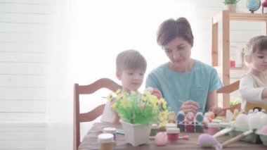 Mutlu Paskalyalar. Paskalya için yumurta boyayan çocuklu aile.