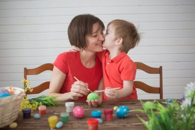 Anne ve oğlu Paskalya yumurtası boyuyor. Mutlu aile Paskalya için hazırlanıyor.