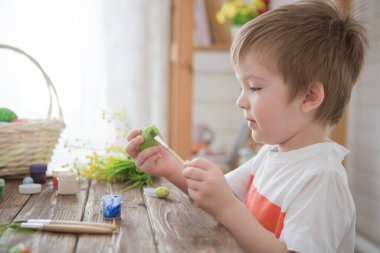 Paskalya yumurtalarını boyayan bir çocuk Paskalya 'yı kutlamaya hazırlanıyor.