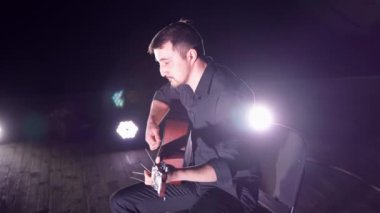 Sahnede gitar çalan adam.