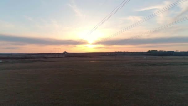 Letecké video elektrického sloupu s dráty proti obloze při západu slunce — Stock video