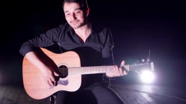 Sahnede gitar çalan adam.
