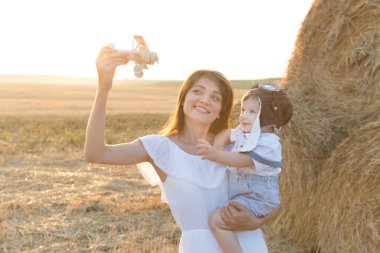 Anne gün batımında parkta yürürken çocuğuna sarılıyor.