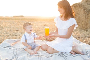 Anne gün batımında parkta yürürken çocuğuna sarılıyor.