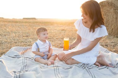 Anne gün batımında parkta yürürken çocuğuna sarılıyor.