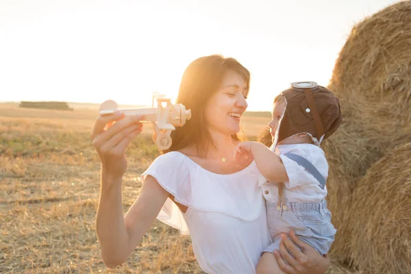 Мати обіймає дитину під час прогулянки в парку над заходом сонця — стокове фото