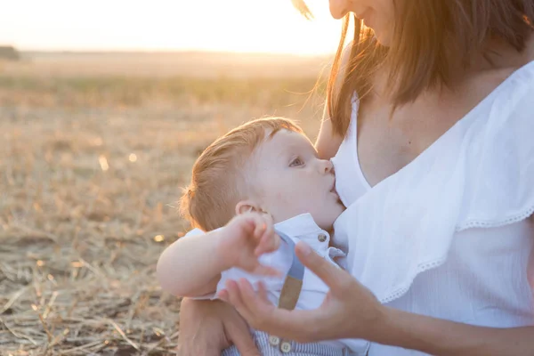 Hermosa madre feliz amamantando a su bebé al aire libre. —  Fotos de Stock