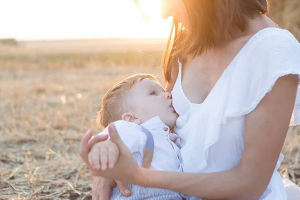 Hermosa madre feliz amamantando a su bebé al aire libre. —  Fotos de Stock