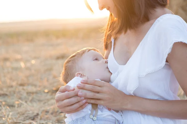 Bela mãe feliz amamentando seu bebê menino ao ar livre. — Fotografia de Stock