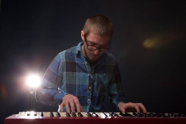 Klavye sentezleyici piyano tuşlarında çalan sanatçı. Erkek müzisyen bir müzik aleti çalıyor.