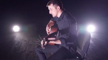 Sahnede gitar çalan adam.