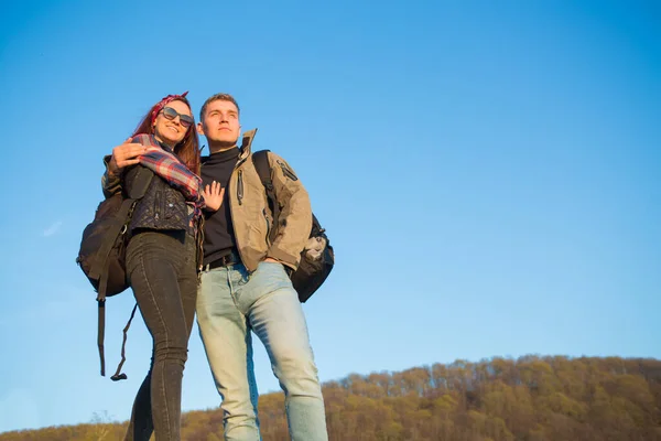 Wandelaars met rugzakken genieten van het uitzicht op de vallei vanaf de top van een berg Wandelen in de bergen — Stockfoto