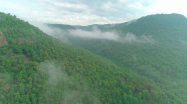 Bulutların, dağların, ormanın ve nehrin havadan çekilmiş videosu.