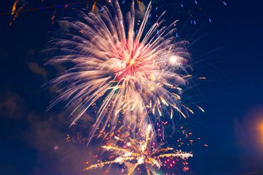 Bulutlu gece gökyüzünün arka planında havai fişekler. 4 Temmuz - Amerikan Bağımsızlık Günü ABD