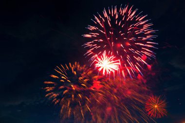 Bulutlu gece gökyüzünün arka planında havai fişekler. 4 Temmuz - Amerikan Bağımsızlık Günü ABD