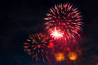 Bulutlu gece gökyüzünün arka planında havai fişekler. 4 Temmuz - Amerikan Bağımsızlık Günü ABD