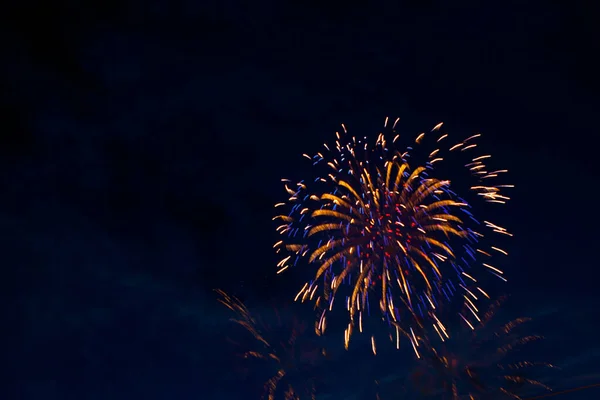 Vuurwerk op de achtergrond van de bewolkte nachtelijke hemel. 4 juli - Amerikaanse Onafhankelijkheidsdag USA — Stockfoto