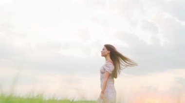 Buğday tarlasında gün batımında beyaz elbiseli bir kız.