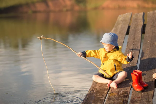 Маленький хлопчик ловить рибу з дерев'яного причалу — стокове фото