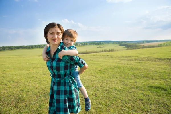 Mother and son having fun on green field — Stock Photo, Image