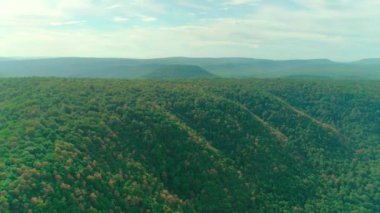 Bulutların, dağların, ormanın ve nehrin havadan çekilmiş videosu.