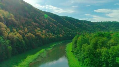 Bulutların, dağların, ormanın ve nehrin havadan çekilmiş videosu.