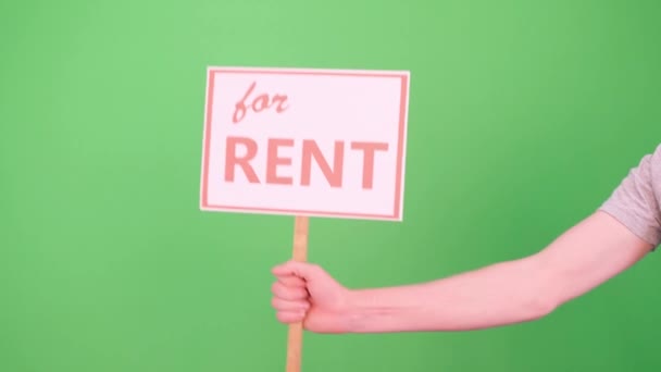 一个男人举起一个标牌，上面有绿色背景的Chromakey，上面写着"为了房租" — 图库视频影像